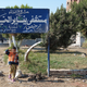 Kids playing at the 25 January hospital entrance sign.